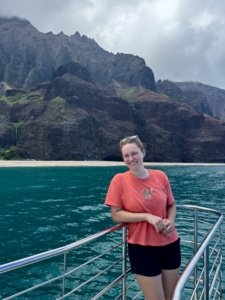 Kaiya leans against the railing of a boat.