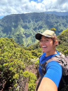 Joanna takes a selfie in front of a mountain view.